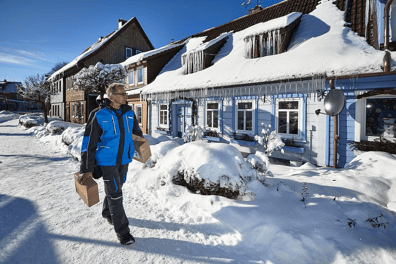 Hermes-Zusteller-liefert-ein-Paeckchen-im-Schnee