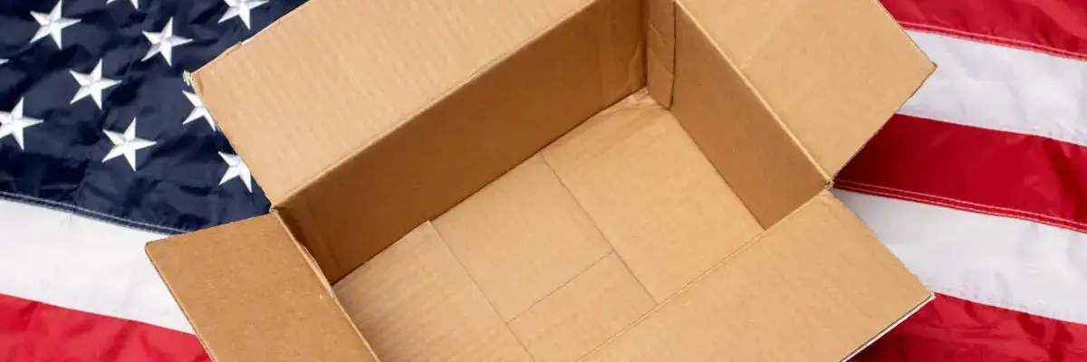 Ein leerer Karton liegt auf der Fahne der USA