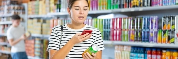 Eine junge Frau scannt den QR-Code auf einem Produkt