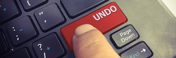 Ein Finger drückt auf einer Tastatur einen Undo-Button